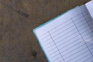 A notebook with a pen sitting on top of a wooden table photo