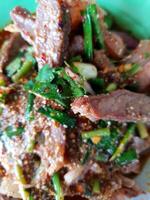 A plate of meat and vegetables with a spoon photo