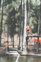 A rope is hanging from a bridge over a pond photo