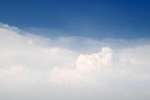 A plane flying in the sky with clouds in the background photo