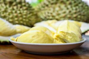 A bowl of durian fruit sitting on a table photo
