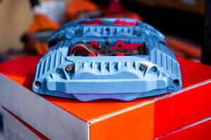 A blue and red car brake on top of a box photo