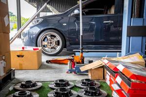 A car is sitting in a garage with a box of tires photo