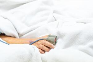 A person laying in a hospital bed with an iv photo