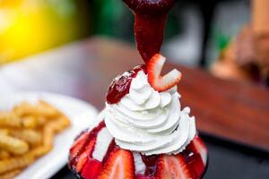 A strawberry sundae with whipped cream and strawberries photo