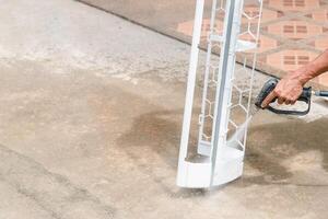 A man is using a power washer to clean a concrete floor photo