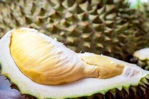 A durian fruit is cut open and sitting on a table photo