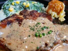 A plate with meat, gravy and vegetables on it photo