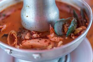 A bowl of soup with a metal spoon photo