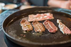 A pan with meat on it sitting on a table photo