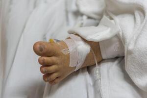 A person in a hospital bed with iv drip photo
