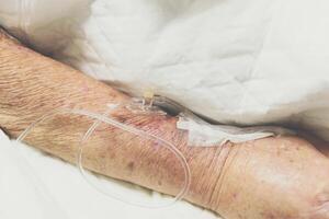 A person in a hospital bed with an iv drip photo