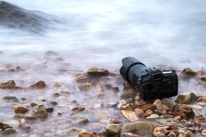 A camera on the rocks by the ocean photo