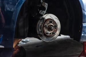 A man is working on a car's brake photo