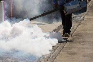A man spraying a white substance on a sidewalk photo