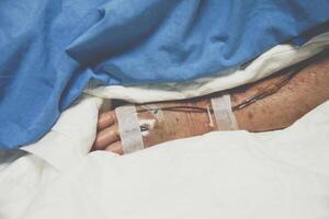 A person in a hospital bed with ivs and a drip photo