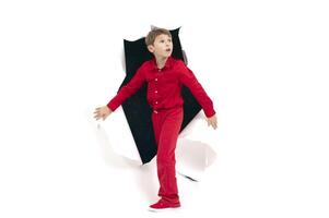 A child from a hole in paper. Boy shows cardboard. photo