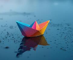 Colorful paper boat floats on a wet surface reflecting vibrant hues in natural light photo