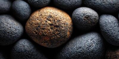A beautiful composition of different grey and brown textured stones on a dark surface. photo
