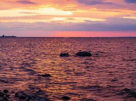 Scenic sunset on the sea. The sky is painted with bright colors. Cloudy summer evening photo