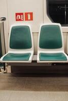 Empty Green and White Seats on a Subway Train in a Urban Transit System at Night photo