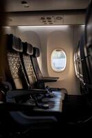 Empty Airplane Interior With Three Dark Seats Beside a Window During Daytime photo