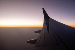 Sunset View From an Airplane Wing Over a Vast Sky During Twilight Hours photo