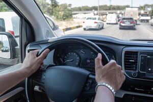 Driving in Heavy Traffic on a Sunny Day With a View of Vehicles Ahead and a Clear Dashboard Display Showing Speed and Conditions photo