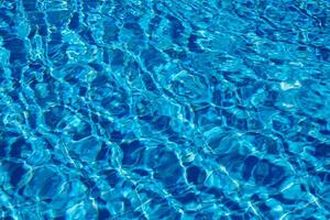 Bright Blue Water Reflecting Sunlight Creates a Serene Atmosphere in a Swimming Pool During a Sunny Afternoon photo