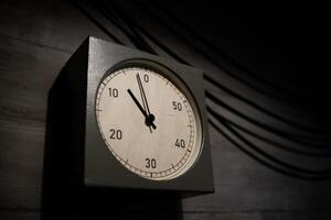 Clock Displaying Time Approaching Zero in a Dimly Lit Room Emphasizing Urgency and Anticipation During an Important Countdown photo