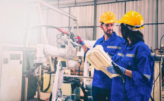 ingenieros mecánico utilizando computadora controlador robótico brazo para soldadura acero en acero fábrica taller. industria robot programación software foto