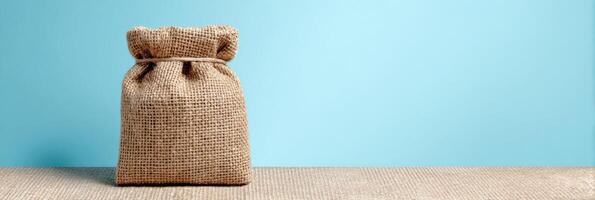 Eco-friendly Packaging Made From Burlap Cloth Displayed Against a Clean Sky-Blue Background With a Side View Showing Its Natural Texture and Appeal photo