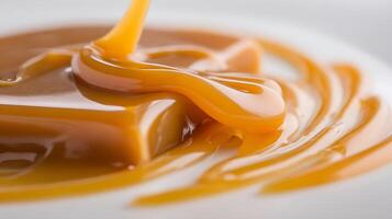 Viscous Caramel Syrup Pouring and Swirling on a White Surface. photo