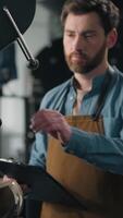 Caucasian man check roaster machine smell roasted coffee beans flavor check quality roasting control checklist middle-aged guy male barista working with caffeine small business owner industry factory video