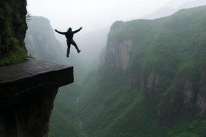 A man jumping off a cliff into the valley below photo