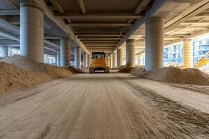 A construction vehicle driving under a bridge photo