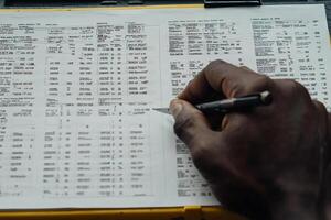 A man's hand writing on a clipboard photo