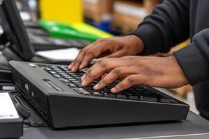 A person typing on a keyboard at a cash register photo