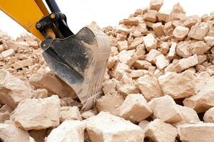 A close up of a bulldozer digging through a pile of rocks photo