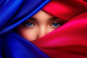 A woman with blue eyes is hidden behind a red and blue fabric photo