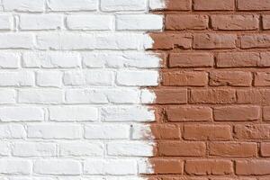 A white and brown brick wall with paint on it photo