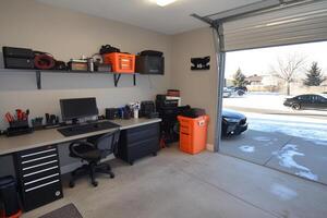 A garage with a desk, computer, and other items photo