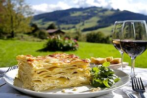 A plate of lasagna on a table with wine glasses photo