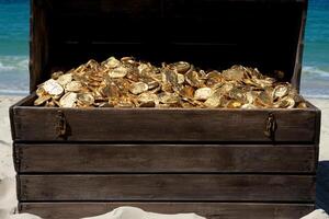 A wooden chest filled with gold coins on the beach photo