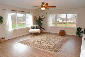 A living room with a rug and a ceiling fan photo