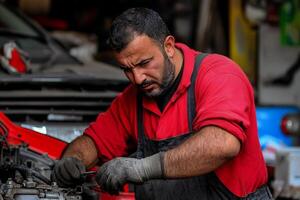 A man in an apron working on a car photo