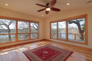 A room with hardwood floors and a ceiling fan photo