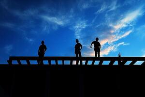 Three men standing on a wooden platform with a blue sky photo