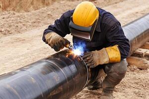 A man welding on a pipe photo