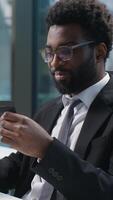 Happy joyful African American man holding banking credit card online buying consumer payment computer buyer businessman male guy shopper business manager employee entrepreneur office client purchase video